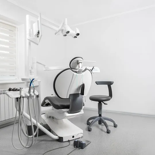 Une salle de soins claire du modèle Roussel, avec le fauteuil, l’éclairage et le tabouret du praticien